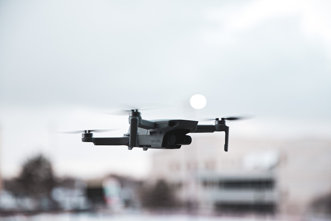 black drone flying in the sky during daytime