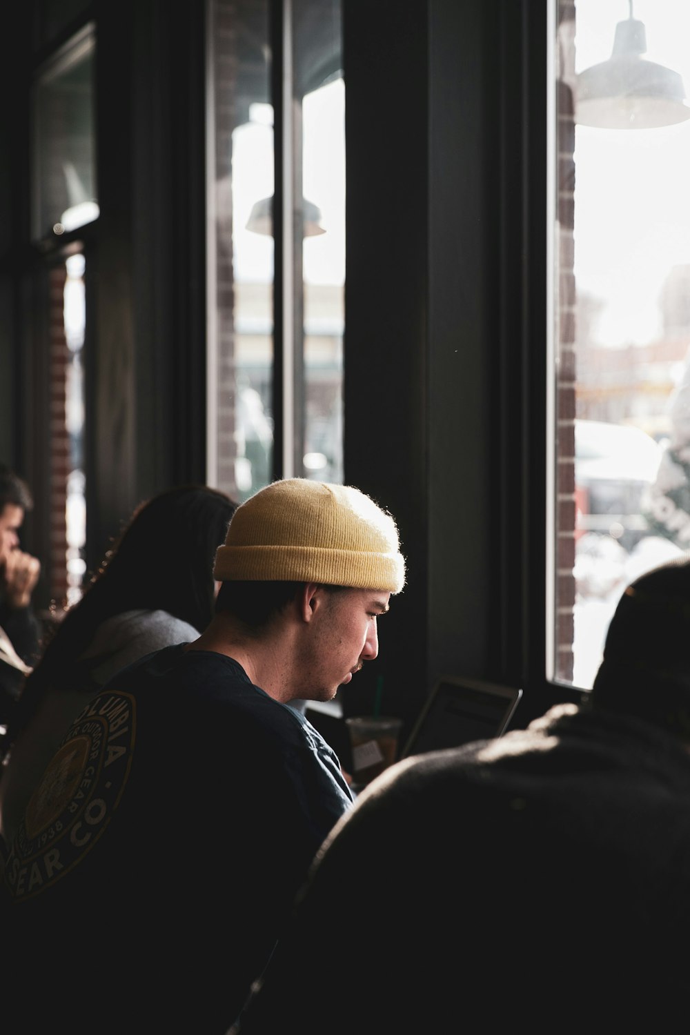 man in black jacket wearing brown knit cap