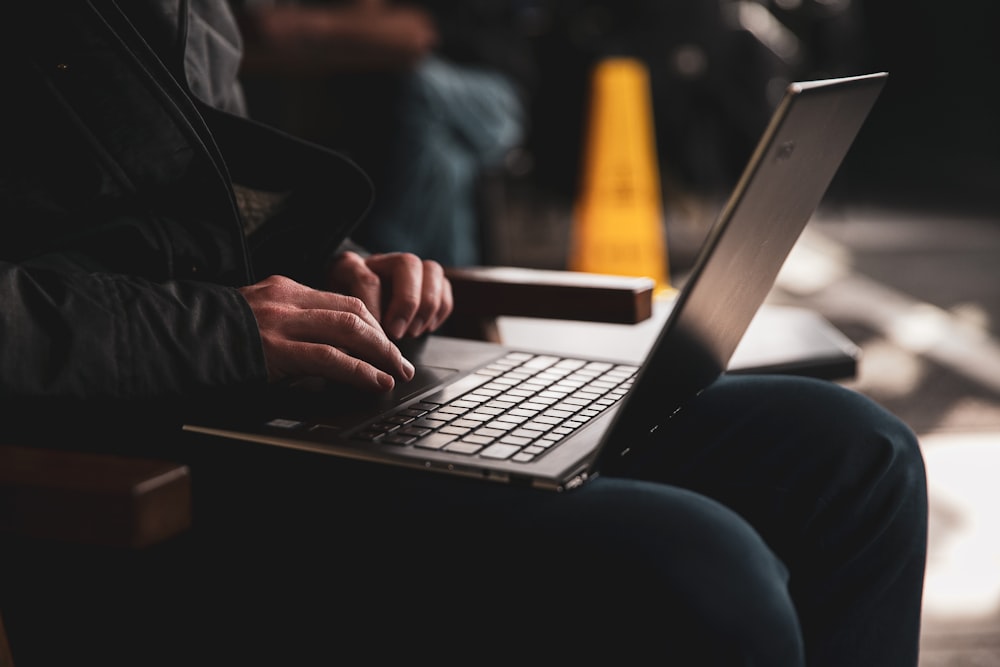 person in brown leather jacket using macbook pro