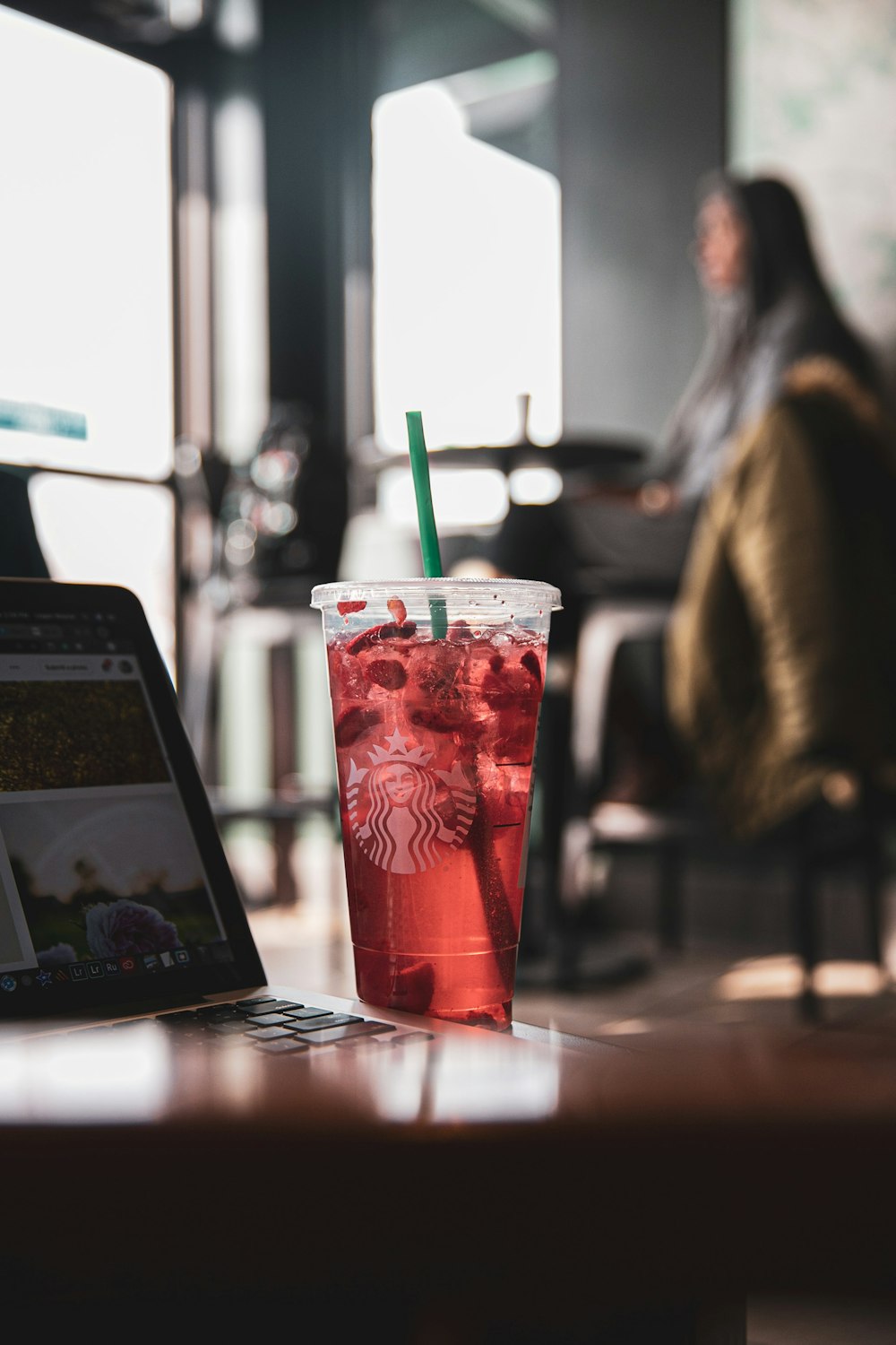 red and white plastic cup with green straw