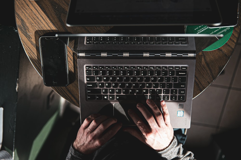 person using gray and black laptop computer