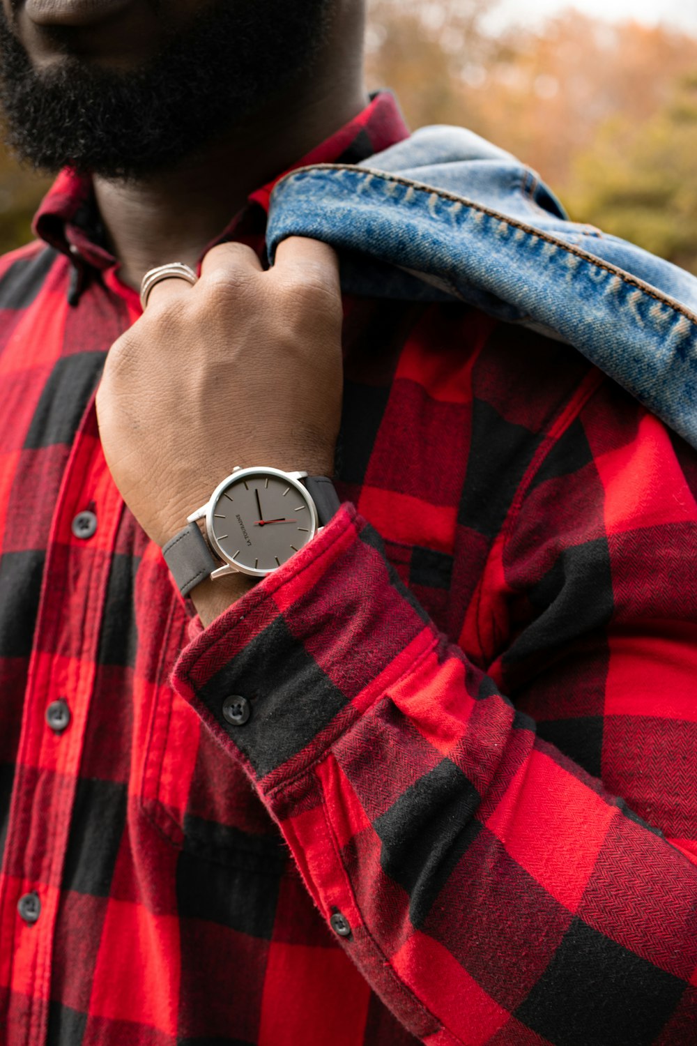 man in red and black plaid dress shirt wearing silver round analog watch