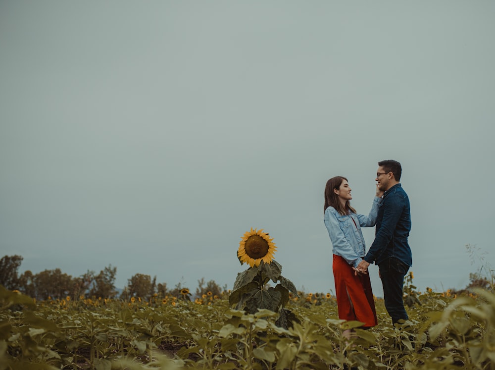 man in blue denim jacket standing beside woman in white long sleeve shirt