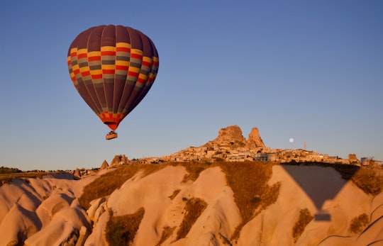 hot air balloon flying over brown mountain during daytime in Cappadocia Turkey