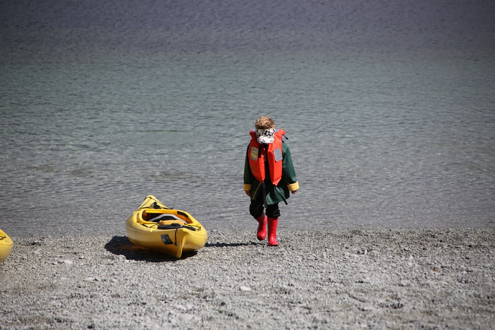 2 women in black and red suit carrying yellow and black inflatable ring on beach during