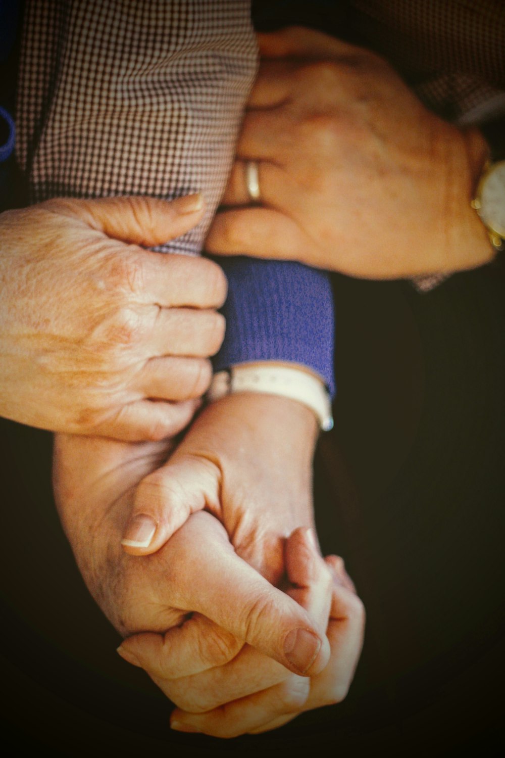 person in blue long sleeve shirt holding babys hand