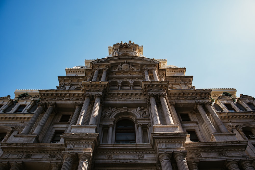 low angle photography of gray concrete building under blue sky during daytime