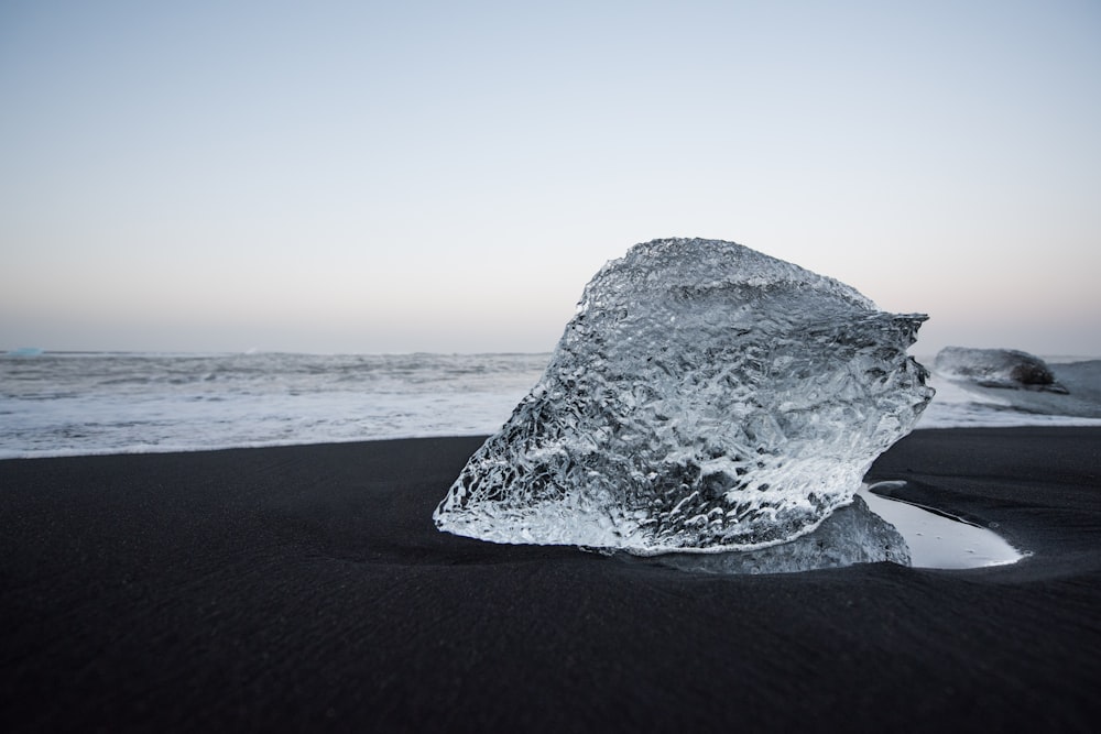 gray rock formation on black sand during daytime