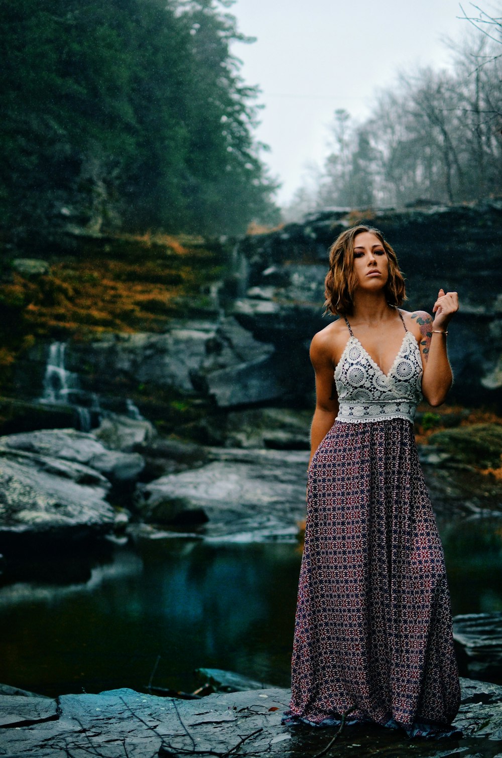 woman in white and red spaghetti strap dress standing near river during daytime