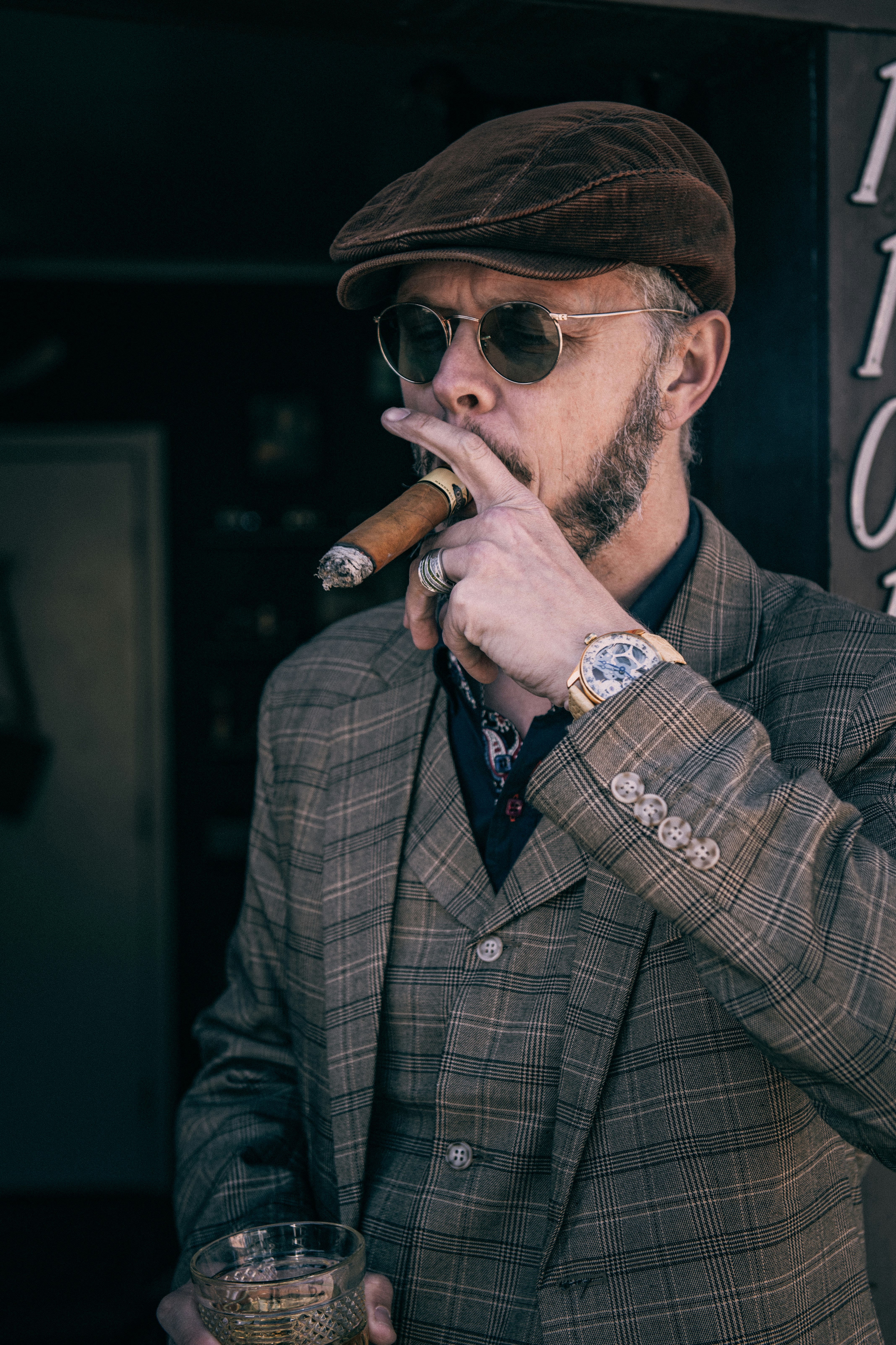man in brown and black plaid coat smoking cigarette