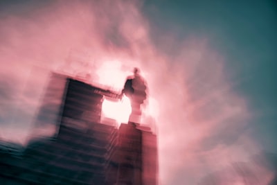 man in white shirt and black pants standing on top of building dreamy zoom background