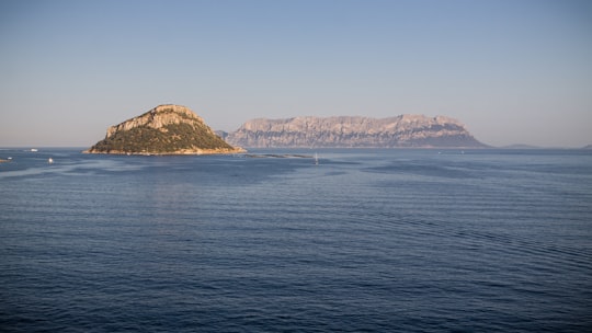 body of water near mountain during daytime in Tavolara Italy