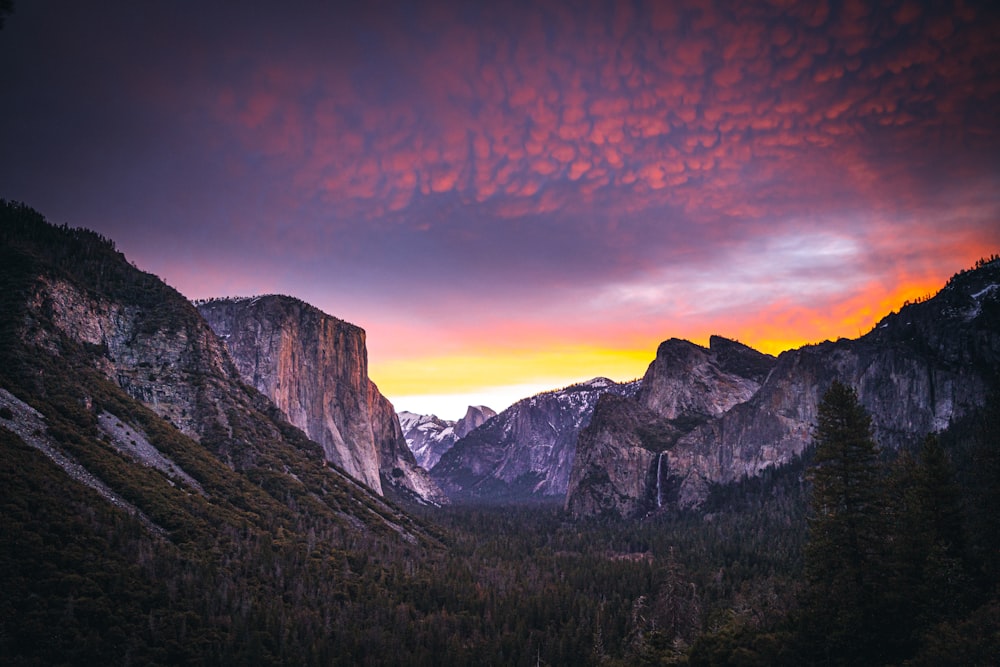 brown and gray mountains under orange and blue sky