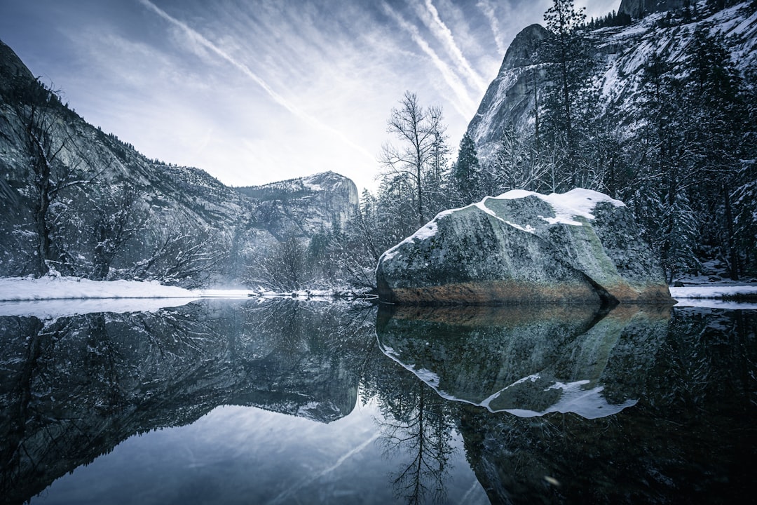 body of water near snow covered mountain during daytime