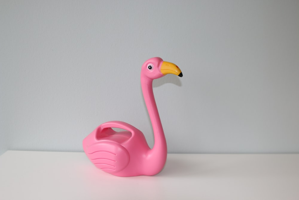 pink flamingo plastic toy on white table