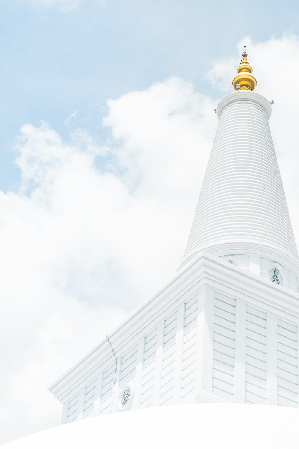 white concrete building under white clouds during daytime