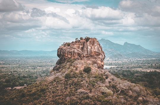 brown rock formation under white clouds during daytime in Pidurangala Rock Sri Lanka