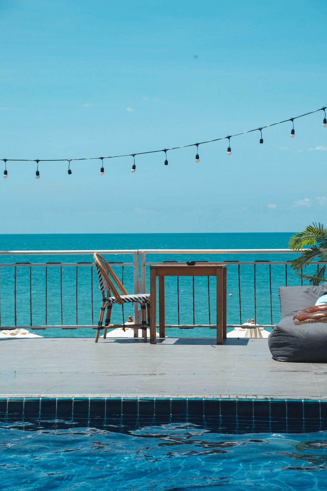 brown wooden chair on white wooden deck near body of water during daytime