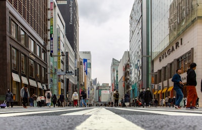 people walking on pedestrian lane in between high rise buildings during daytime