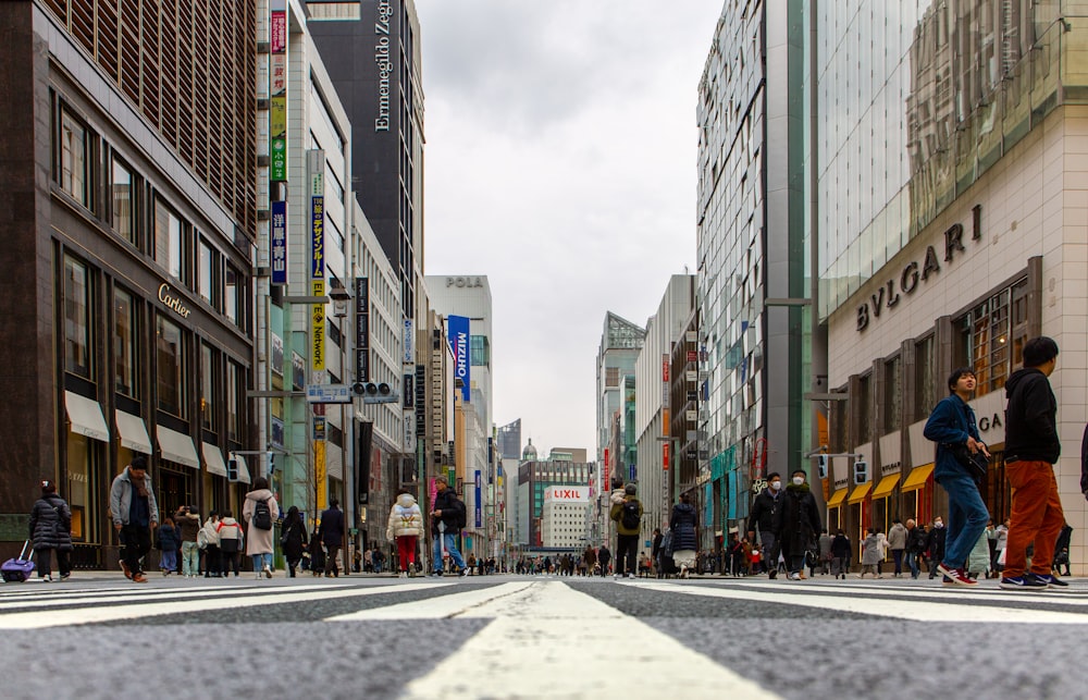 people walking on pedestrian lane in between high rise buildings during daytime