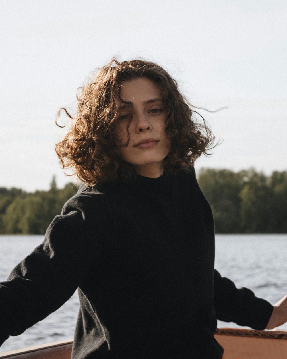 woman in black long sleeve shirt standing near body of water during daytime