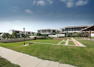 white concrete building near green grass field under blue sky during daytime