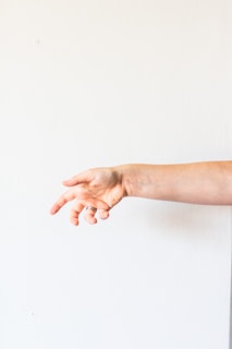 persons hand on white surface