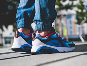 Casual street shot of someone wearing bright sneakers against an urban backdrop.