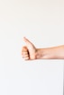 persons right hand doing thumbs up