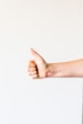 persons right hand doing thumbs up