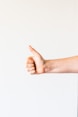 persons right hand doing thumbs up