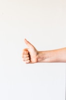 persons right hand doing thumbs up