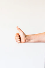 persons right hand doing thumbs up