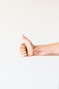 persons right hand doing thumbs up