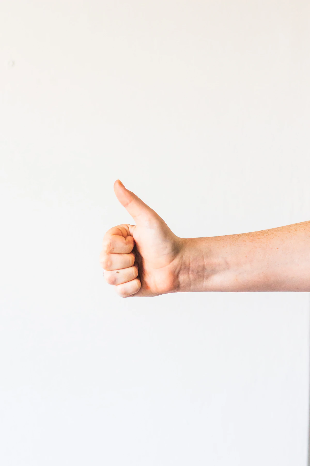 Persons right hand doing thumbs up
