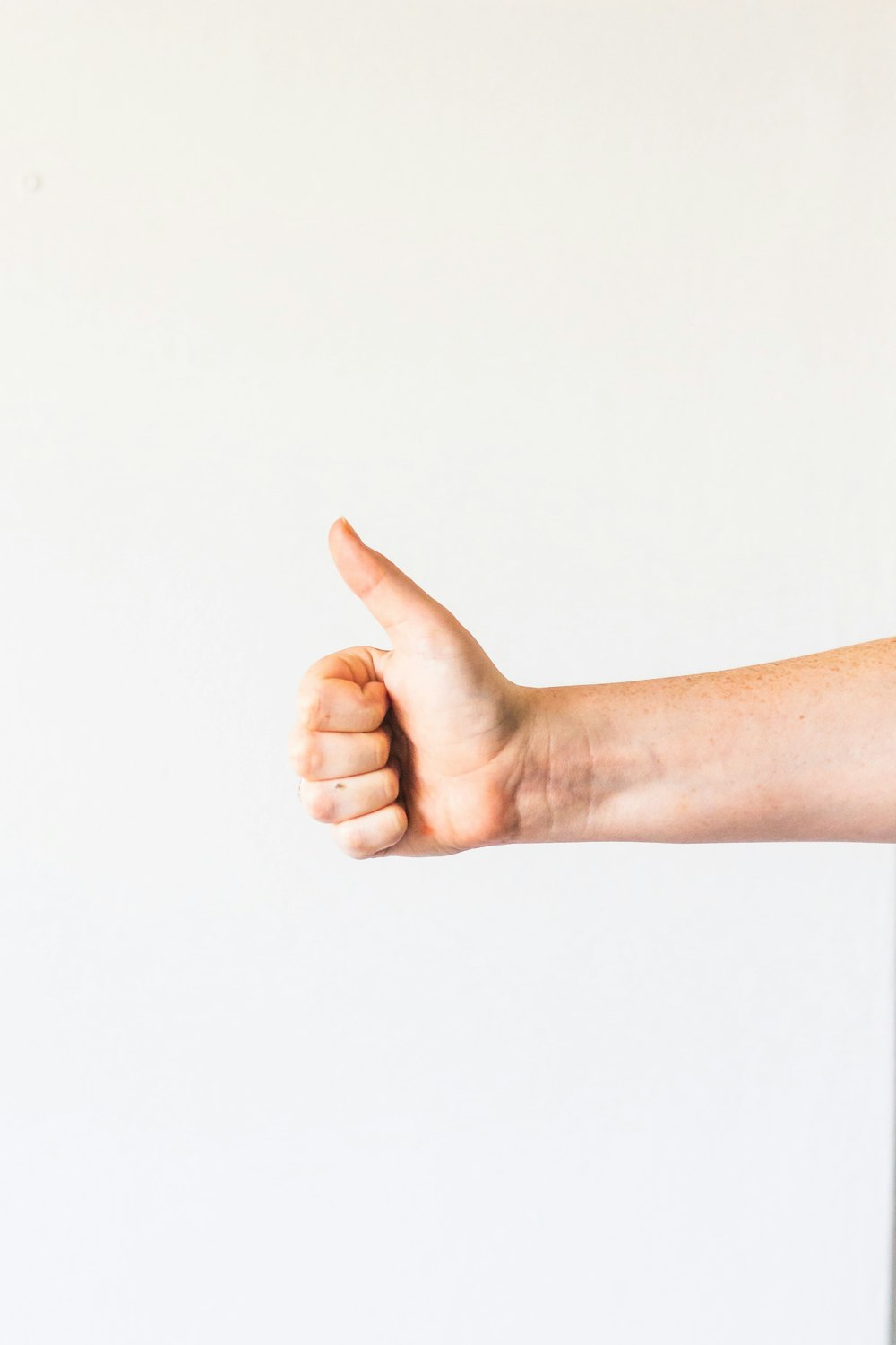 la mano derecha de las personas haciendo el pulgar hacia arriba