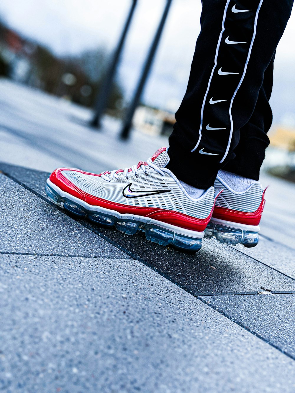 person wearing black white and red nike athletic shoes