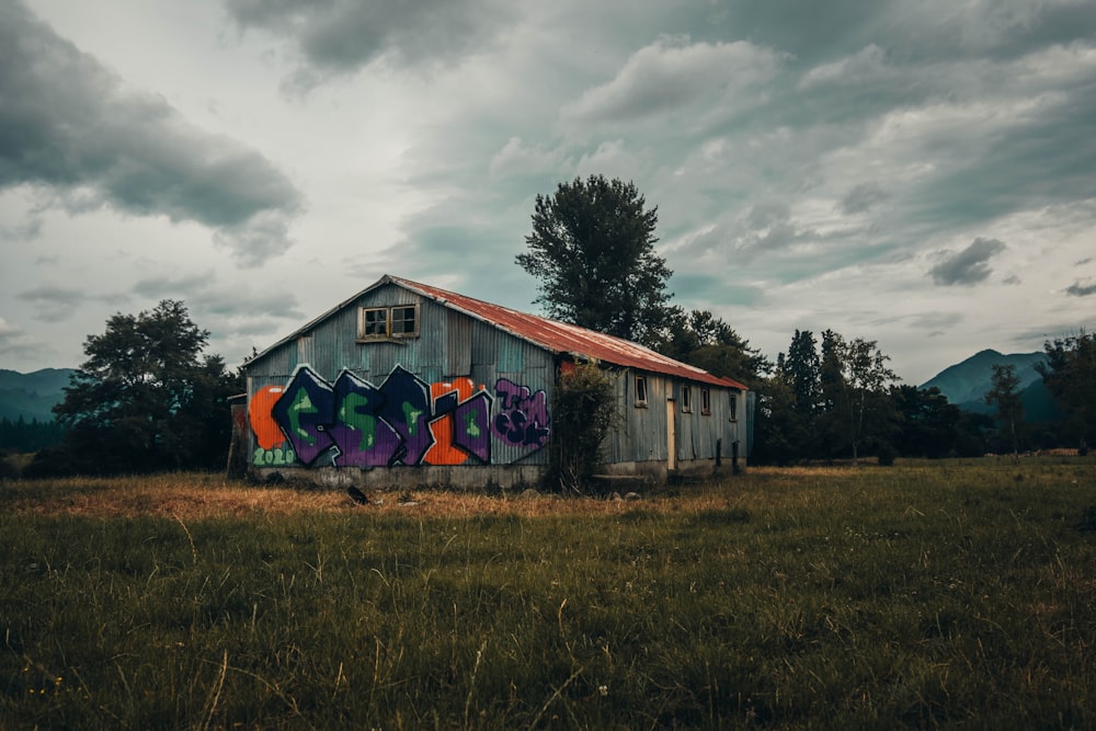 blaues und rotes Holzhaus unter grauen Wolken