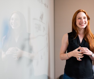 woman in blue tank top standing beside white wall