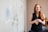 woman in blue tank top standing beside white wall