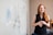 woman in blue tank top standing beside white wall