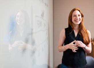 woman in blue tank top standing beside white wall