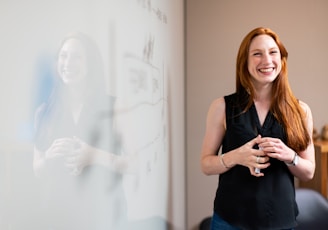 woman in blue tank top standing beside white wall