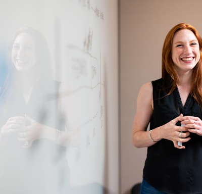 woman in blue tank top standing beside white wall