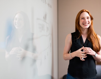 woman in blue tank top standing beside white wall