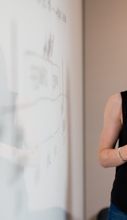 woman in blue tank top standing beside white wall