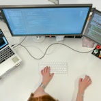 person using macbook pro on white table