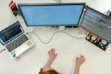 person using macbook pro on white table