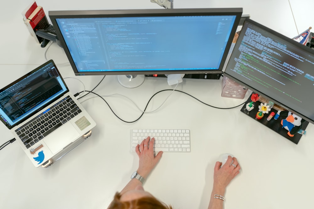 person using macbook pro on white table