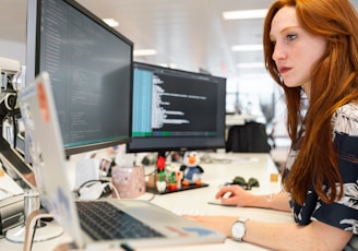 woman in green shirt sitting in front of computer